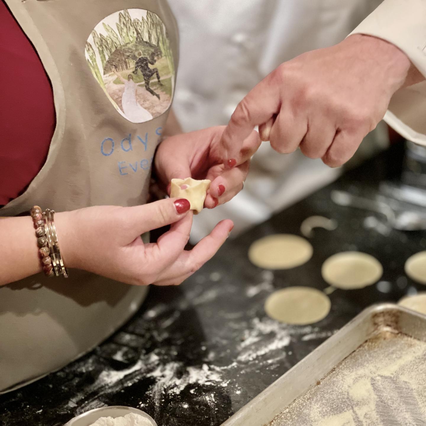 Chef shows woman how to make a tortellini pasta