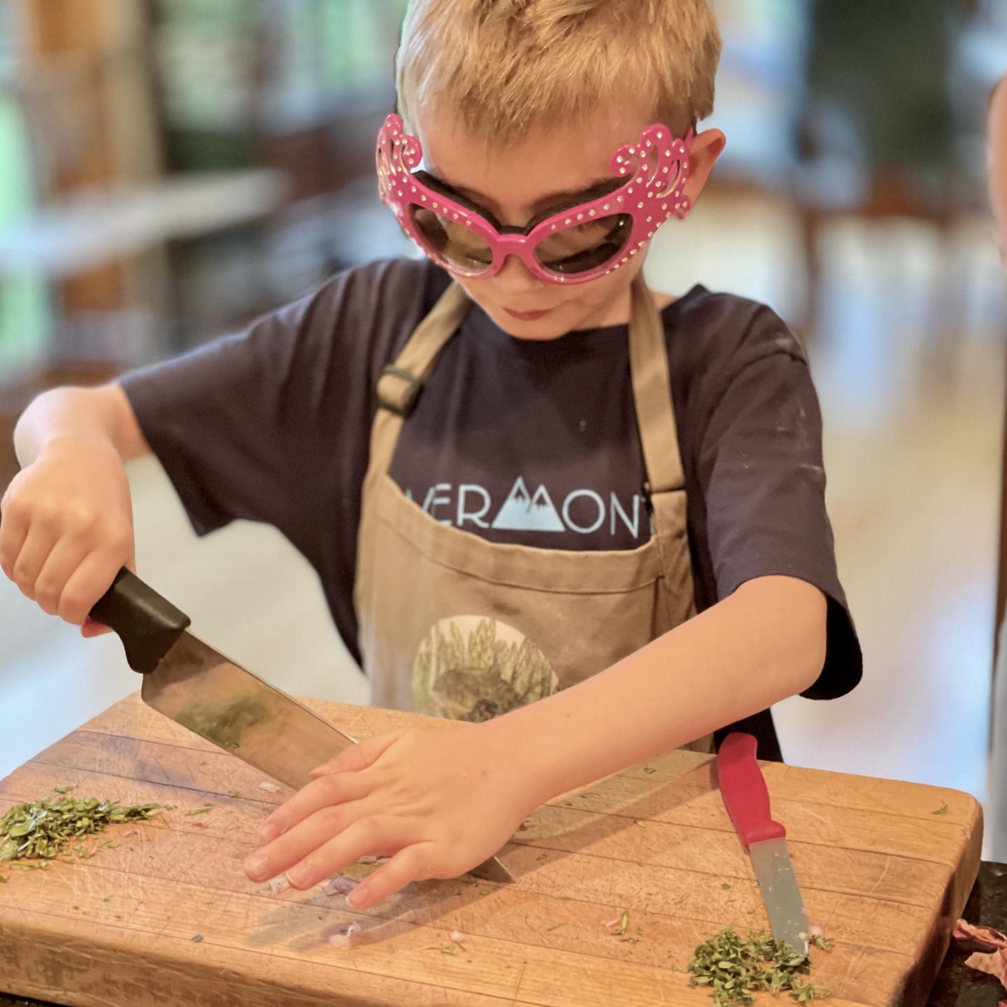 Boy chopping onions with pink glasses